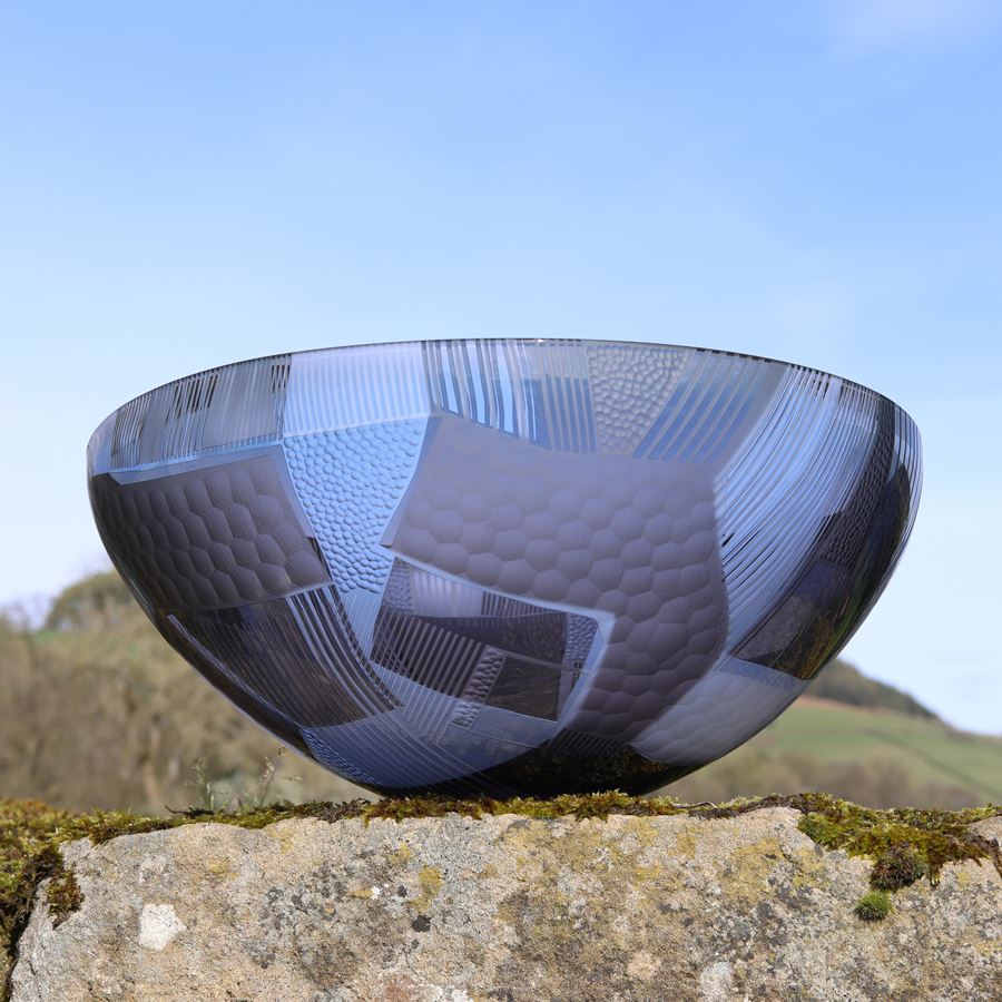 grey clear and aqua wide open bowl with cut abstract landscape patterns on both the interior and exterior surfaces hand made from glass